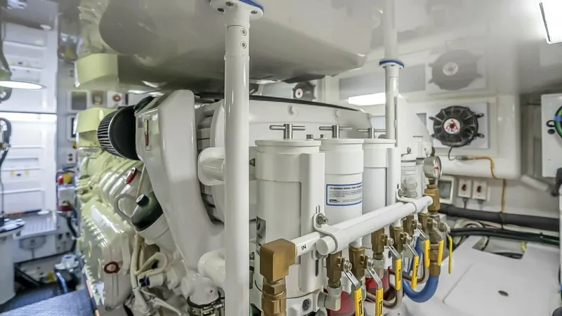Slide: The Image of Engine Room with Advanced Systems The engine room of the 2021 Viking 48 Convertible showcases state-of-the-art mechanical systems and meticulous organization. High-quality components, including fuel filters and robust piping, are arranged for optimal performance and easy maintenance. The - 7224907