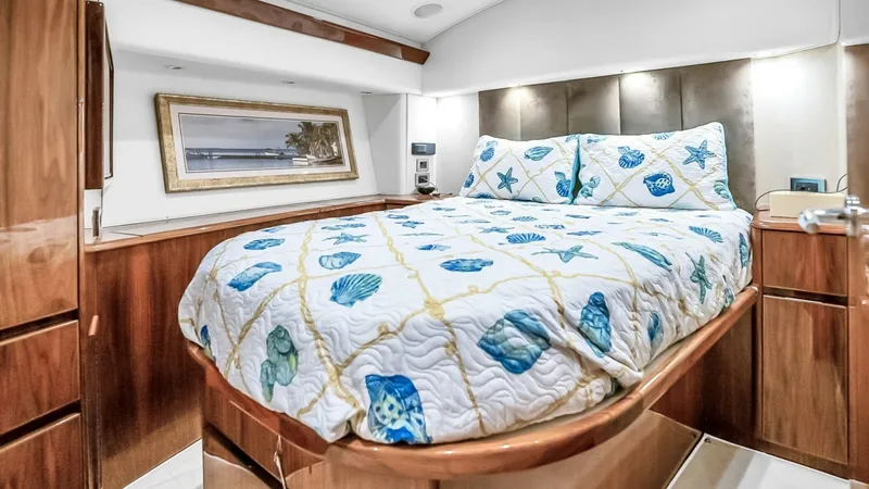 Slide: The Image of Viking 48 Convertible Master Stateroom The master stateroom aboard the Viking 48 Convertible features a plush double berth with elegant, nautical-themed bedding. Rich wood cabinetry and soft overhead lighting create a warm and inviting atmosphere, while the built-in storage ensures ample space - 7224866