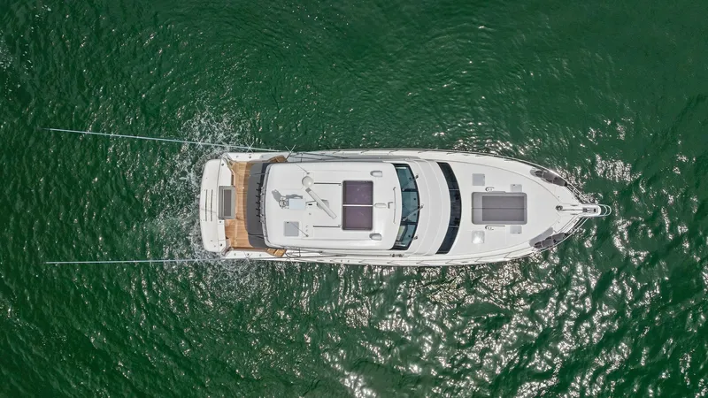Slide: The Image of Aerial View of Enclosed Bridge The 2021 Riviera 57 Enclosed Bridge is showcased from above, highlighting its sleek design and spacious layout. The expansive deck features ample space for relaxation, while the enclosed bridge offers a commanding view for navigation. This aerial perspect - 7541543