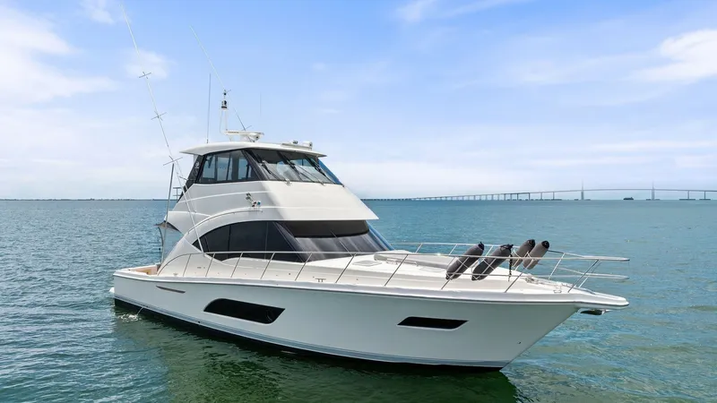Slide: The Image of Starboard Side with Enclosed Bridge The 2021 Riviera 57 Enclosed Bridge is showcased from the starboard side, highlighting its sleek lines and modern design. The enclosed bridge offers a commanding view, perfect for all-weather navigation. The spacious foredeck with stainless steel railings - 7541531