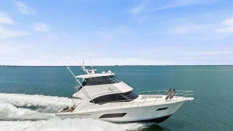 Slide: The Image of Exterior Side View in Motion The 2021 Riviera 57 Enclosed Bridge is showcased cruising powerfully through open waters. Its sleek, modern design is complemented by large windows and a commanding flybridge, offering exceptional visibility and style. The yacht's elegant lines and robust - 7541545