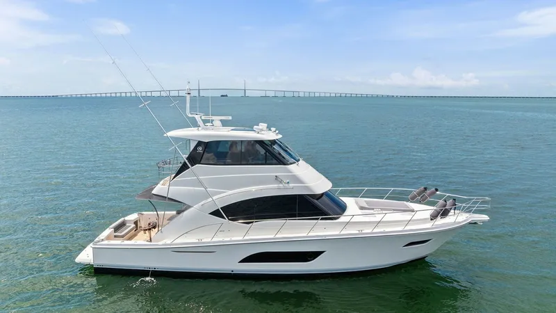 Slide: The Image of Side Profile of Riviera 57 Enclosed Bridge This image showcases the elegant side profile of the 2021 Riviera 57 Enclosed Bridge. The sleek lines and modern design are complemented by large panoramic windows that offer stunning views and natural light. The spacious aft deck and sophisticated enclos - 7541535