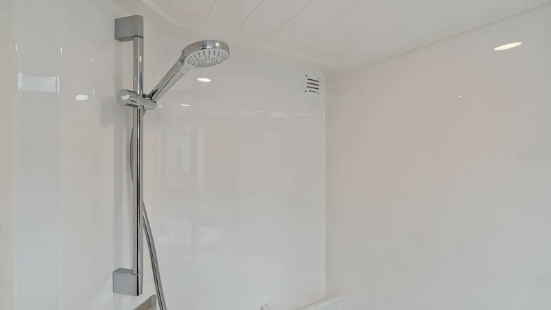 Slide: The Image of Luxury Yacht Shower Enclosure This pristine shower enclosure on the 2021 Riviera 57 Enclosed Bridge features sleek, modern fixtures and a polished white finish. The adjustable showerhead and streamlined design offer both functionality and elegance, creating a spa-like experience at se - 7541519