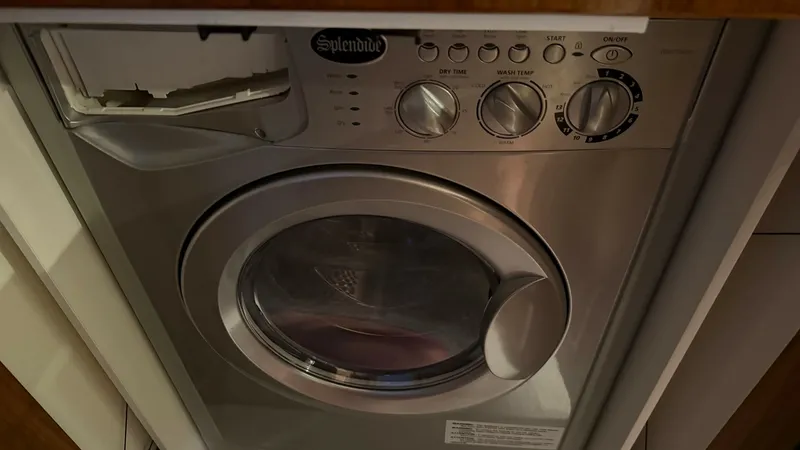 Slide: The Image of Laundry Area with Washer/Dryer This image showcases the convenient laundry area of the 2021 Riviera 57 Enclosed Bridge, featuring a compact Splendide washer/dryer unit. The space-efficient design ensures onboard comfort and practicality, allowing for easy garment care during extended v - 7396153