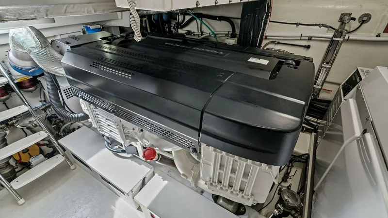 Slide: The Image of Engine Room with Power Unit The engine room of the 2021 Riviera 57 Enclosed Bridge showcases a powerful and meticulously organized engine setup. The clean, spacious layout allows for easy access to essential components, ensuring efficient maintenance and operation. High-quality mate - 7541525
