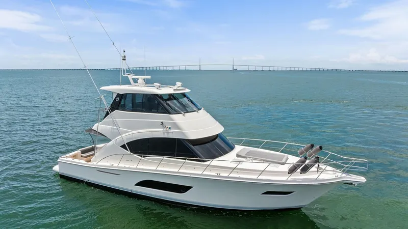 Slide: The Image of Side Profile of Riviera 57 Enclosed Bridge This image showcases the sleek side profile of the 2021 Riviera 57 Enclosed Bridge. The vessel features a streamlined hull with large panoramic windows, providing ample natural light and stunning views. The enclosed flybridge offers protection and comfort - 7541541