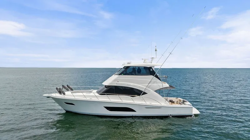 Slide: The Image of Profile View of Riviera 57 Enclosed Bridge This image showcases the sleek profile of the 2021 Riviera 57 Enclosed Bridge, highlighting its elegant lines and spacious design. The vessel's enclosed bridge offers superior visibility and protection from the elements, making it ideal for extended cruis - 7541537