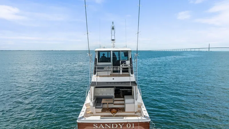Slide: The Image of Aft Deck and Enclosed Bridge View This image showcases the sleek aft deck of the 2021 Riviera 57 Enclosed Bridge, featuring comfortable seating and a spacious entertainment area. The enclosed bridge offers enhanced visibility and protection, ideal for navigating various conditions. The el - 7541532
