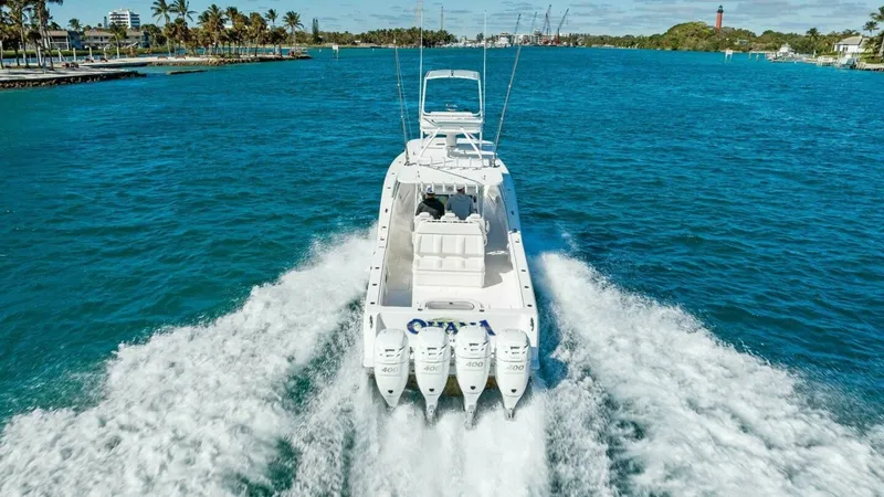 Slide: The Image of Aerial View of Stern and Engines This dynamic aerial shot captures the powerful quad outboard engines propelling the 2019 Invincible 42 Open Fisherman, 'Ohana'. The spacious aft deck is designed for both functionality and comfort, ideal for fishing and leisure. The vessel's sleek design - 7285543