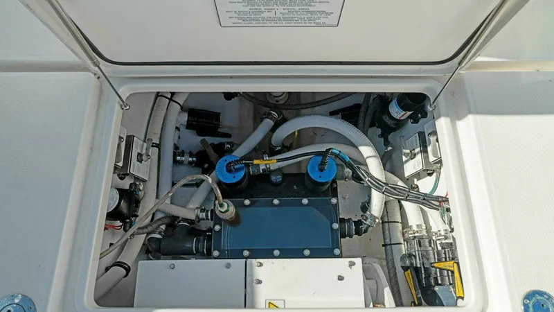 Slide: The Image of Engine Compartment Access Hatch This image showcases the engine compartment of the 2019 Invincible 42 Open Fisherman, featuring a well-organized layout for ease of maintenance. The compartment is equipped with durable hoses and secure fittings, reflecting the vessel's high build quality - 7285527