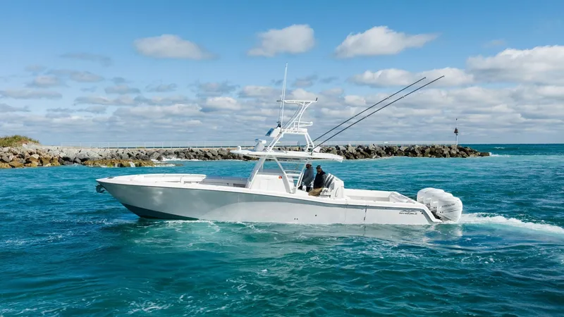 The Image of Side Profile of Invincible 42 Open Fisherman The 2019 Invincible 42 Open Fisherman, named Ohana, is showcased cruising through vibrant blue waters. Its sleek hull design and powerful outboard engines provide a perfect blend of performance and elegance. The center console layout offers ample space fo - 7285502