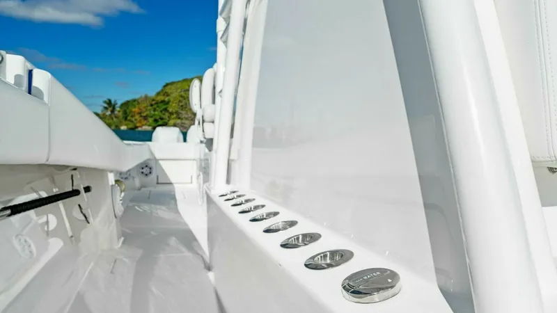 Slide: The Image of Side Deck with Rod Holders The side deck of the 2019 Invincible 42 Open Fisherman features sleek, integrated rod holders, perfect for avid anglers. The polished stainless steel accents complement the clean, white finish, offering both style and functionality. This area provides eas - 7285517