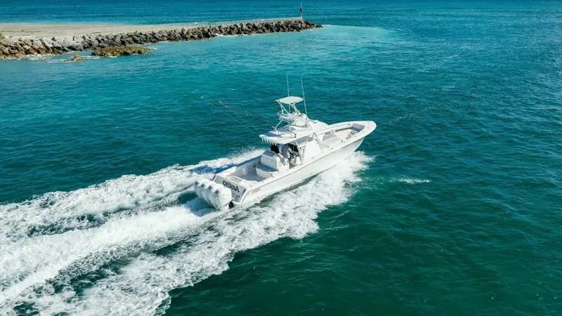 Slide: The Image of Aerial View of 42 Open Fisherman This stunning aerial shot captures the Invincible 42 Open Fisherman slicing through turquoise waters. The vessel, named Ohana, showcases its powerful quad outboard engines, delivering exceptional speed and performance. The sleek design and spacious deck a - 7285540