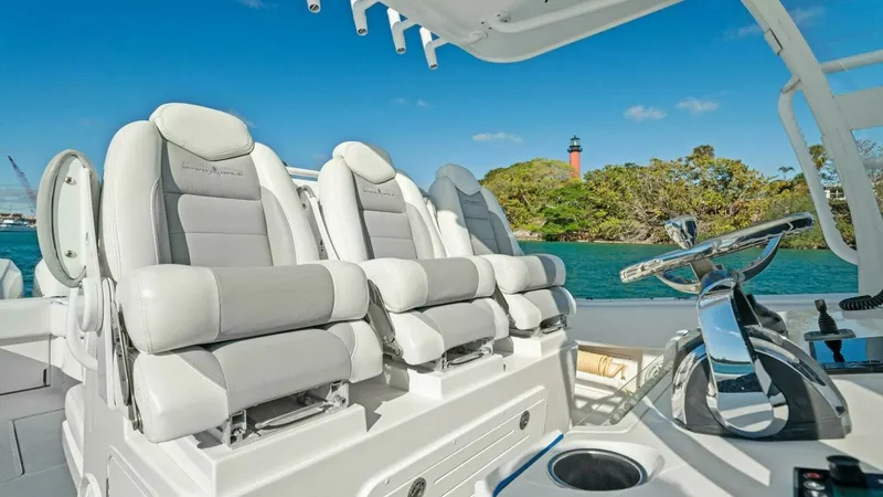 Slide: The Image of Helm Seating and Console View The Invincible 42 Open Fisherman's helm area features luxurious, ergonomic seating with plush cushioning and sleek design. The console is equipped with modern navigation controls, offering a seamless and intuitive experience for the captain. Overhead, a s - 7285511