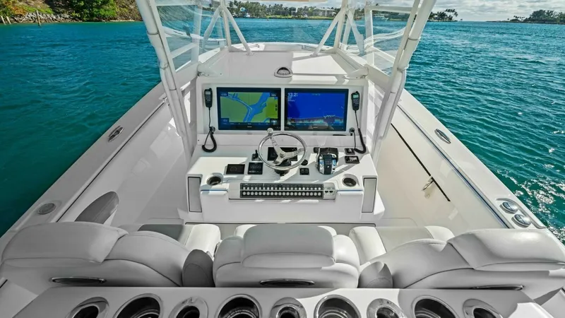 Slide: The Image of Helm Station with Dual Displays The helm station of the 2019 Invincible 42 Open Fisherman features dual high-definition displays, offering advanced navigation and control. Sleek, white upholstery provides comfortable seating, complemented by a row of integrated cup holders for convenien - 7285503