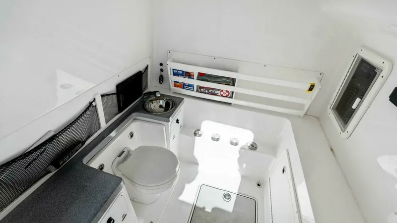 Slide: The Image of Spacious Enclosed Head Area This image showcases the enclosed head area of the 2019 Invincible 42 Open Fisherman. The space features a compact yet functional layout with a marine toilet, sink, and practical storage solutions. The bright, white finish and efficient use of space make - 7285519