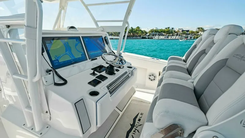 Slide: The Image of Helm Station with Seating The helm station of the 2019 Invincible 42 Open Fisherman offers a sleek and modern design, featuring dual high-definition navigation screens for precise control. The ergonomic layout includes three cushioned helm seats, ensuring comfort during long voyag - 7285508