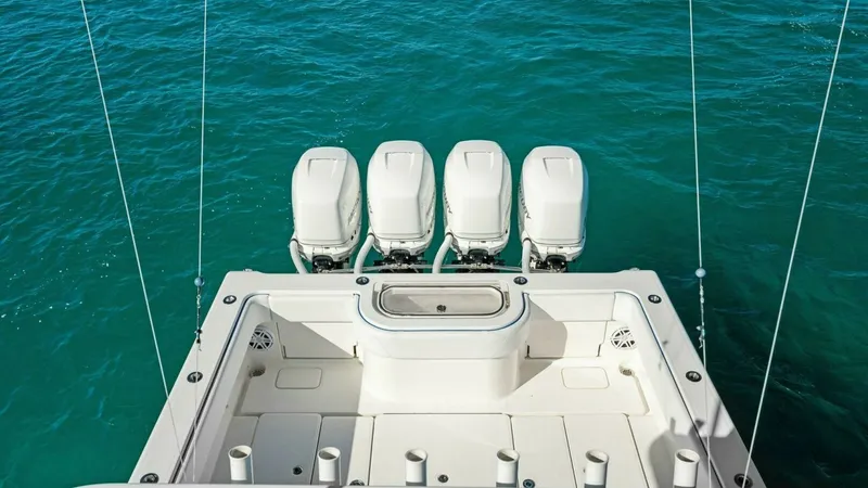 Slide: The Image of Aft Deck with Quad Outboard Engines This image showcases the impressive aft deck of the 2019 Invincible 42 Open Fisherman, featuring a powerful quad outboard engine setup. The spacious layout provides ample room for fishing activities, complemented by strategically placed rod holders and a - 7285532