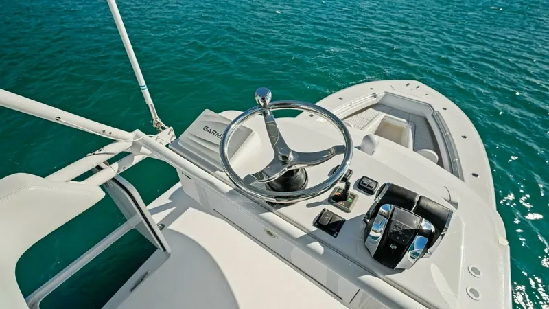 Slide: The Image of Flybridge Helm Station Overview This image captures the sleek and functional helm station located on the flybridge of the 2019 Invincible 42 Open Fisherman. Featuring a minimalist design, the station is equipped with a stainless steel steering wheel and state-of-the-art controls for pre - 7285530