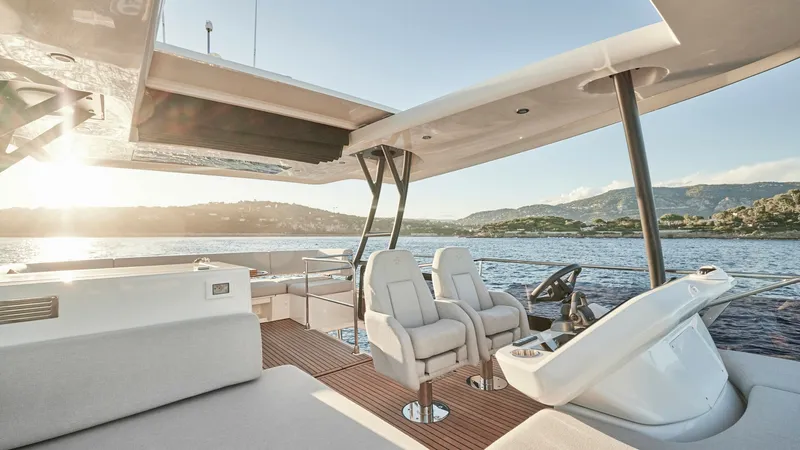 Slide: The Image of Flybridge Helm with Seating Area This image showcases the elegant flybridge of the 2027 Prestige F5.7, featuring a state-of-the-art helm station with dual captain's chairs. The spacious seating area is designed for comfort and relaxation, offering panoramic views of the surrounding water - 7312524