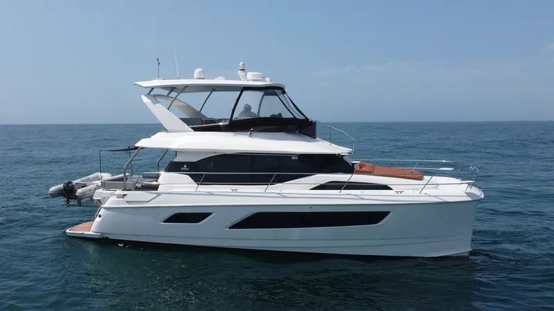 Slide: The Image of Starboard Profile of Aquila 44 CAT This side view showcases the sleek design of the 2021 Aquila 44 CAT, highlighting its modern lines and spacious flybridge. The expansive windows provide ample natural light to the interior, while the well-appointed deck areas promise comfort and luxury. I - 7414043