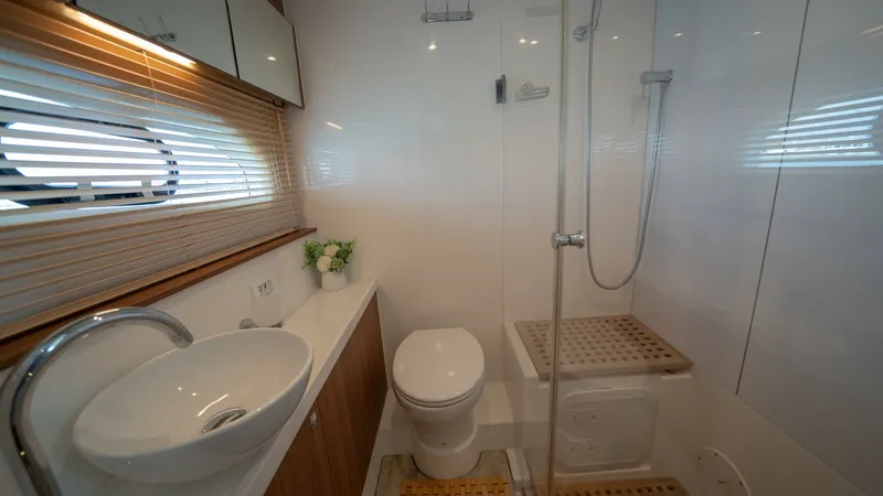 Slide: The Image of Luxurious Ensuite Bathroom This elegant ensuite bathroom on the 2021 Aquila 44 CAT features a sleek, modern design with high-quality finishes. The spacious layout includes a stylish vessel sink, a contemporary faucet, and a glass-enclosed shower with teak accents, offering both fun - 7413959