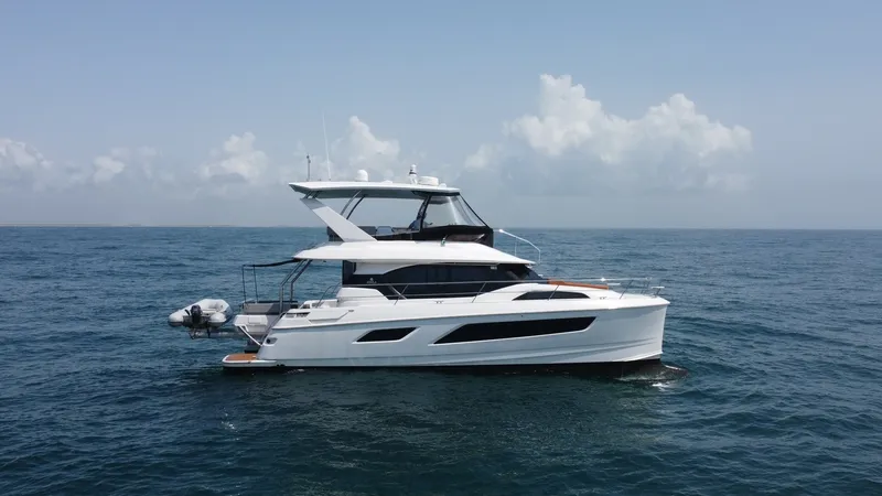 Slide: The Image of Port Side Exterior View This image showcases the sleek port side profile of the 2021 Aquila 44 CAT 'Hey Beautiful'. The modern lines and expansive windows highlight the yacht's contemporary design while ensuring ample natural light inside. The flybridge offers an elevated vantag - 7414032