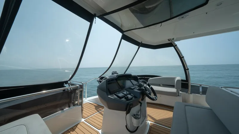 Slide: The Image of Upper Helm Station with Panoramic Views The upper helm station of the Aquila 44 CAT offers expansive panoramic views, perfect for navigating open waters. This area features a state-of-the-art control panel and comfortable seating, all under a protective hardtop. The sleek, modern finishes and t - 7413985