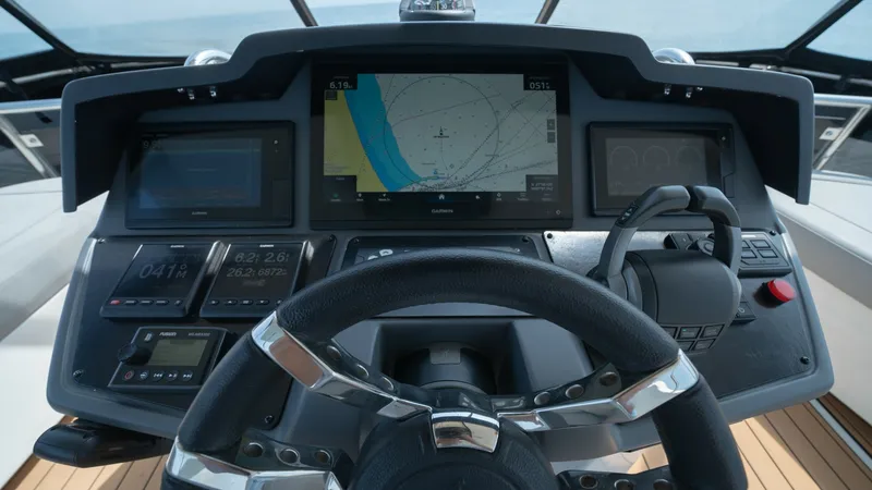Slide: The Image of Helm Station with Navigation Display The helm station of the 2021 Aquila 44 CAT features a sophisticated navigation setup with multiple digital displays. The central screen prominently shows a detailed chart plotter, providing essential navigational information at a glance. The ergonomic ste - 7413989
