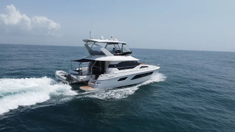 Slide: The Image of Aquila 44 CAT Aft View The 2021 Aquila 44 CAT showcases a sleek aft design, highlighting its spacious upper deck and modern hull lines. The vessel is equipped with a swim platform and a tender, ideal for easy water access and adventure. Its elegant silhouette and expansive wind - 7414030