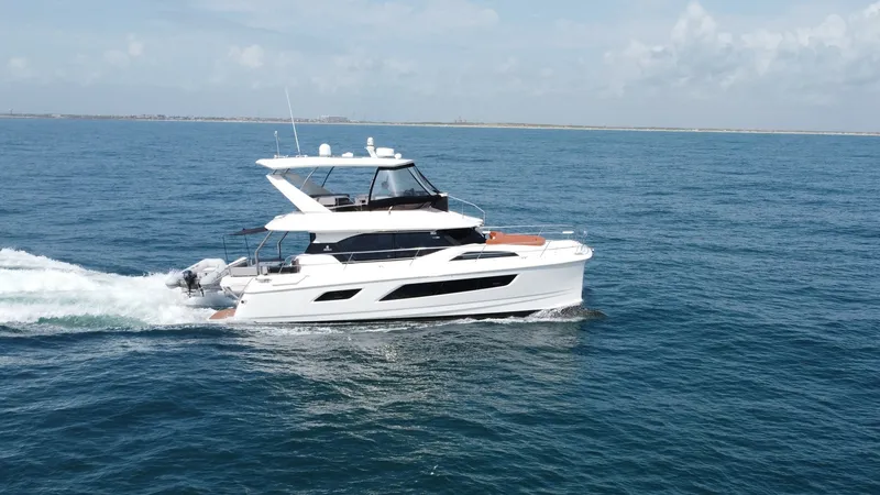 Slide: The Image of Aquila 44 CAT Cruising Side View The 2021 Aquila 44 CAT 'Hey Beautiful' glides effortlessly across the open water, showcasing its sleek and modern design. With expansive windows and a spacious flybridge, this vessel offers stunning panoramic views and ample outdoor seating. The clean lin - 7414009