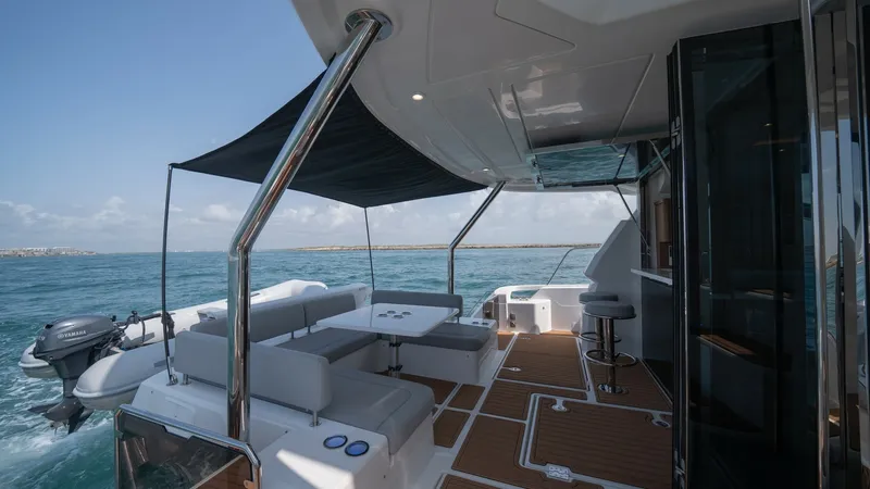 Slide: The Image of Aft Deck with Seating Area The aft deck of the 2021 Aquila 44 CAT features a spacious seating area, perfect for entertaining and relaxation. The elegant teak flooring complements the sleek, modern design, while the overhead canopy provides ample shade. With easy access to the water - 7413975