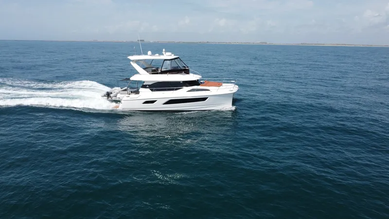 Slide: The Image of Aquila 44 CAT Cruising Profile The 2021 Aquila 44 CAT is shown gracefully cruising on open waters, showcasing its sleek and modern design. The vessel's flybridge provides an elevated view, enhancing both navigation and leisure experiences. With its distinctive hull and spacious layout, - 7414004