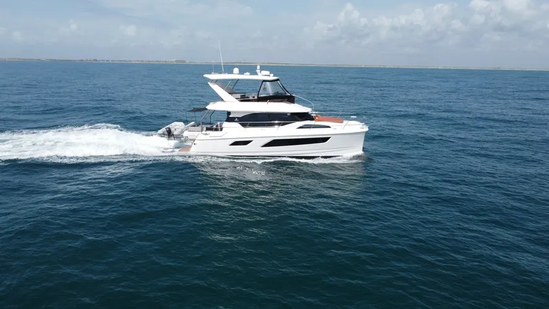 Slide: The Image of Aquila 44 CAT Cruising Side View The 2021 Aquila 44 CAT glides effortlessly over calm waters, showcasing its sleek, modern design. The vessel's spacious flybridge and contemporary profile offer an inviting space for relaxation and panoramic views. Its powerful twin hulls ensure stability - 7414006