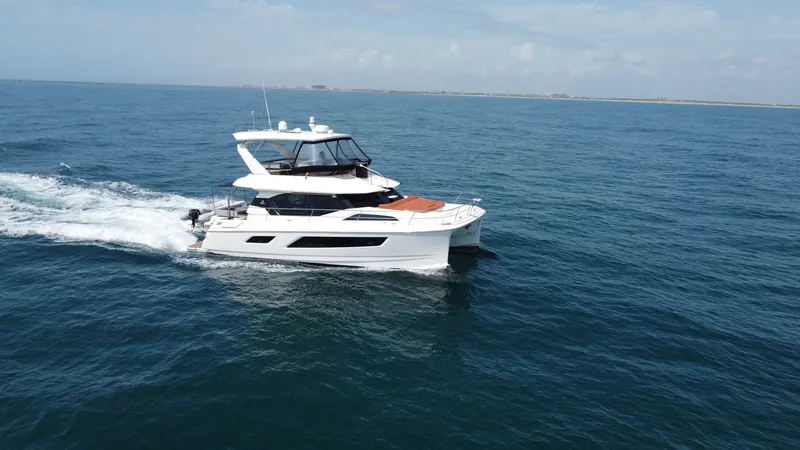 Slide: The Image of Aquila 44 CAT Cruising Side View The 2021 Aquila 44 CAT 'Hey Beautiful' is captured cruising gracefully on open waters. This side profile showcases its sleek, modern design with expansive windows and a spacious flybridge. Its catamaran hull ensures stability and smooth sailing, making it - 7414012