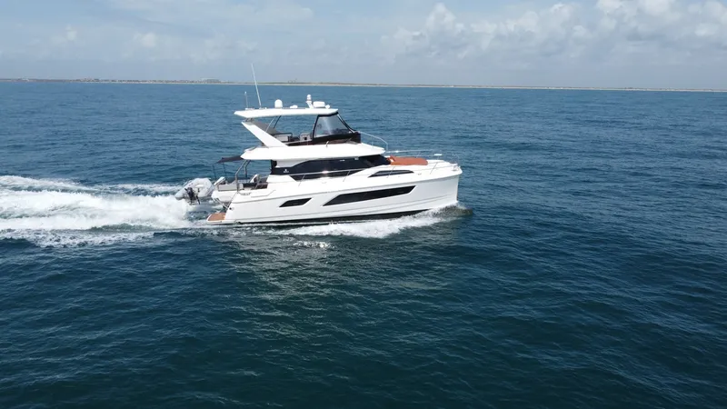 Slide: The Image of Aquila 44 CAT Cruising Side View The 2021 Aquila 44 CAT, 'Hey Beautiful', glides smoothly across the water, showcasing its sleek and modern design. The vessel's spacious flybridge and elegant lines are prominently visible, highlighting its luxurious appeal. With ample deck space and cont - 7414007
