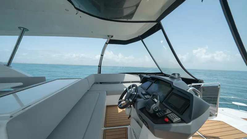 Slide: The Image of Flybridge Helm Station and Seating Area This image showcases the helm station and seating area on the flybridge of the 2021 Aquila 44 CAT. The helm is equipped with advanced navigation systems and a sleek steering wheel, providing an excellent command center with panoramic views. The comfortabl - 7413984