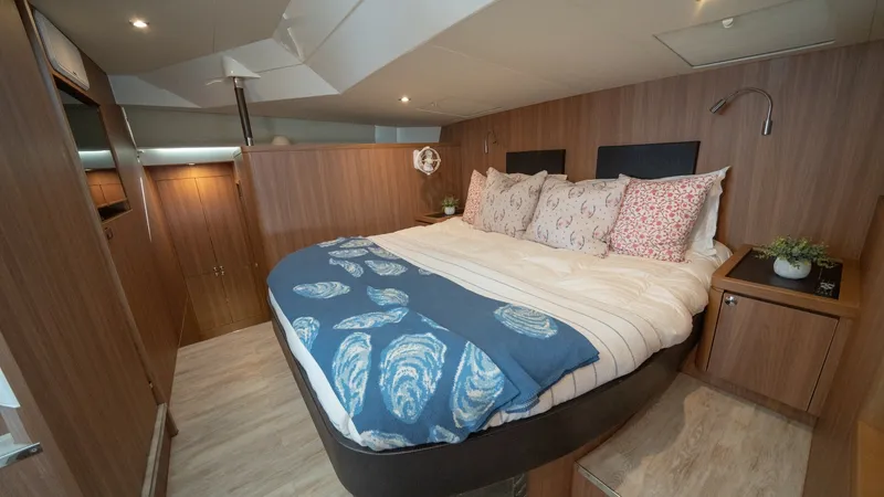 Slide: The Image of Luxurious Master Stateroom The master stateroom on the 2021 Aquila 44 CAT features a spacious and inviting layout with a plush double bed adorned with elegant bedding. Rich wood finishes and ambient lighting create a warm and sophisticated atmosphere. Ample storage and thoughtful d - 7413969