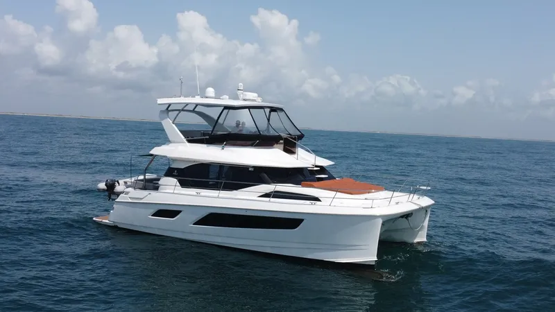 Slide: The Image of Side Profile of Aquila 44 CAT The Aquila 44 CAT showcases a sleek and modern design with its spacious flybridge and elegant lines. The side profile highlights the expansive windows, allowing for abundant natural light and stunning panoramic views inside. The vessel's robust catamaran - 7414033
