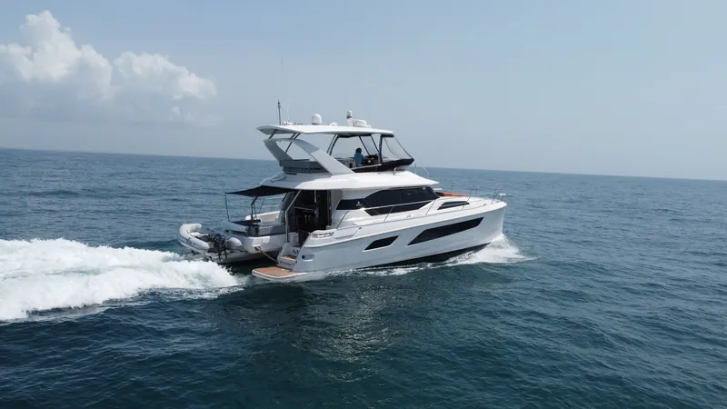 Slide: The Image of Aquila 44 CAT Port Side View The 2021 Aquila 44 CAT 'Hey Beautiful' is captured cruising effortlessly through the water, showcasing its sleek and modern design. The spacious flybridge is visible, offering ample seating and panoramic views, perfect for entertaining. The vessel's elega - 7414029