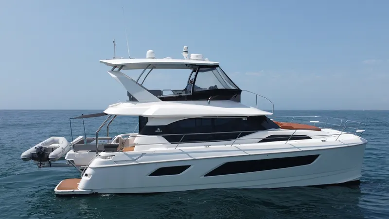 Slide: The Image of Port Side View with Flybridge This image showcases the sleek port side of the Aquila 44 CAT, highlighting its spacious flybridge with protective glass panels and ample seating. The vessel's modern design features streamlined windows and a well-equipped aft deck, perfect for leisure an - 7414041