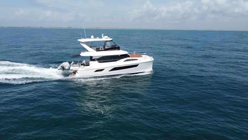 Slide: The Image of Aquila 44 CAT Cruising Side Profile The Aquila 44 CAT is gracefully cruising through open waters, showcasing its sleek profile and modern design. The vessel features a spacious flybridge with ample seating and a commanding helm station, ideal for panoramic views. Its elegant lines and robus - 7414008