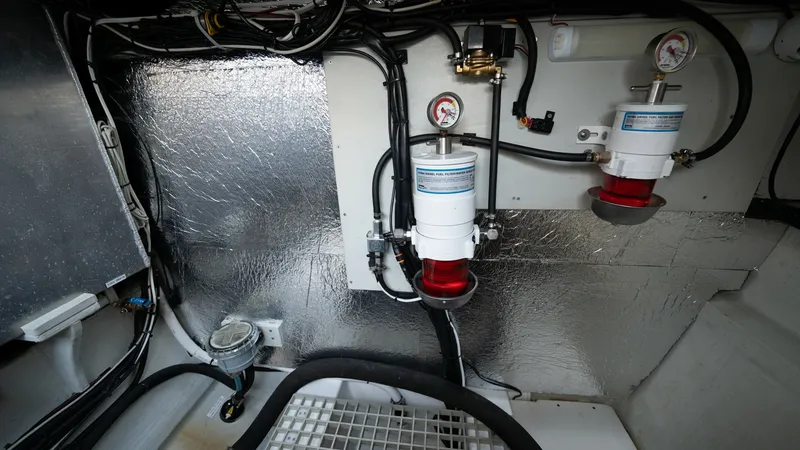 Slide: The Image of Engine Room with Fuel Filters The engine room of the 2021 Aquila 44 CAT features dual fuel filters, showcasing a well-organized and efficient layout. The reflective insulation on the walls enhances thermal management, while the neatly arranged wiring and components ensure easy access - 7413991