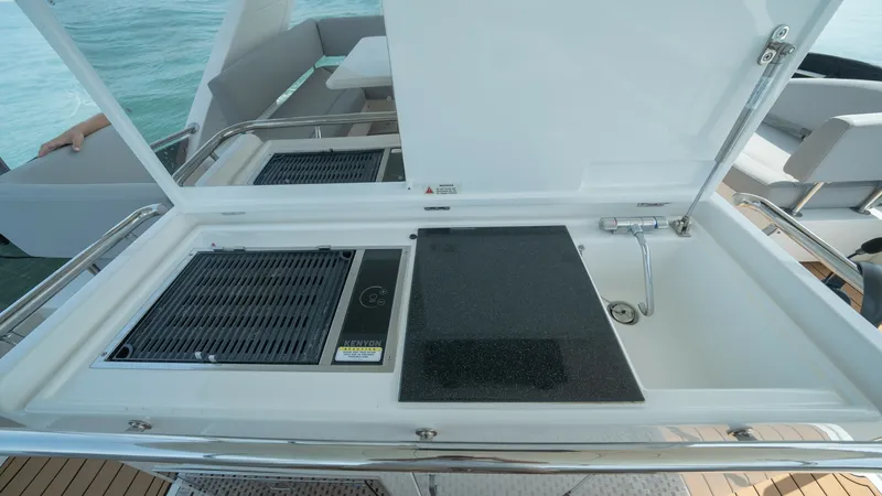 Slide: The Image of Outdoor Galley with Grill and Sink This image showcases the outdoor galley of the 2021 Aquila 44 CAT, featuring a sleek built-in grill and a convenient sink. The galley is designed with durable surfaces and ample workspace, perfect for alfresco dining while enjoying the ocean view. The lay - 7413982