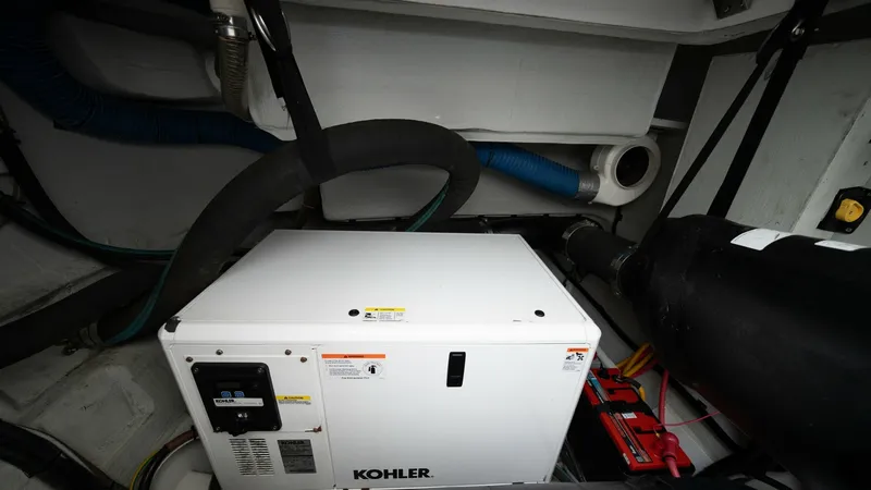 Slide: The Image of Engine Room with Kohler Generator This image showcases the engine room of the Aquila 44 CAT, featuring a Kohler generator. The compact and efficient layout maximizes functionality and accessibility, ensuring reliable power for onboard systems. Well-organized wiring and secure mounts refle - 7413992