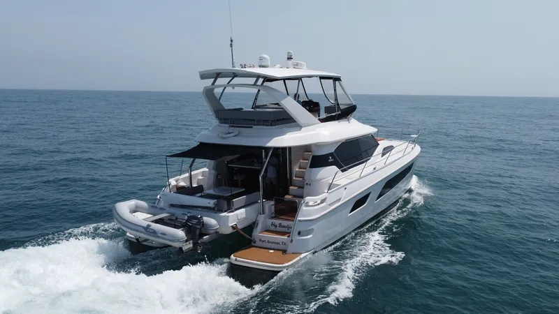 Slide: The Image of Aft View with Swim Platform This image showcases the elegant aft section of the 2021 Aquila 44 CAT, featuring a spacious swim platform perfect for easy water access. The sleek design is complemented by a comfortable seating area and a convenient stairway leading to the upper deck. I - 7414027