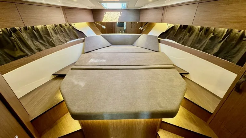 Slide: The Image of Forward Cabin with Convertible Berth This inviting forward cabin of the 2022 Beneteau Antares 11 features a convertible berth, offering both comfort and versatility for overnight stays. The elegant wood finishes and ambient lighting create a warm, welcoming atmosphere. Ample storage and thou - 7403686