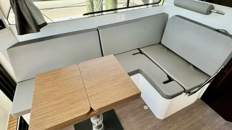 Slide: The Image of Convertible Dinette in Salon The salon features a versatile convertible dinette with sleek, modern seating upholstered in durable fabric. A beautifully finished wooden table complements the space, offering both style and functionality. Large windows provide ample natural light, enhan - 7403681
