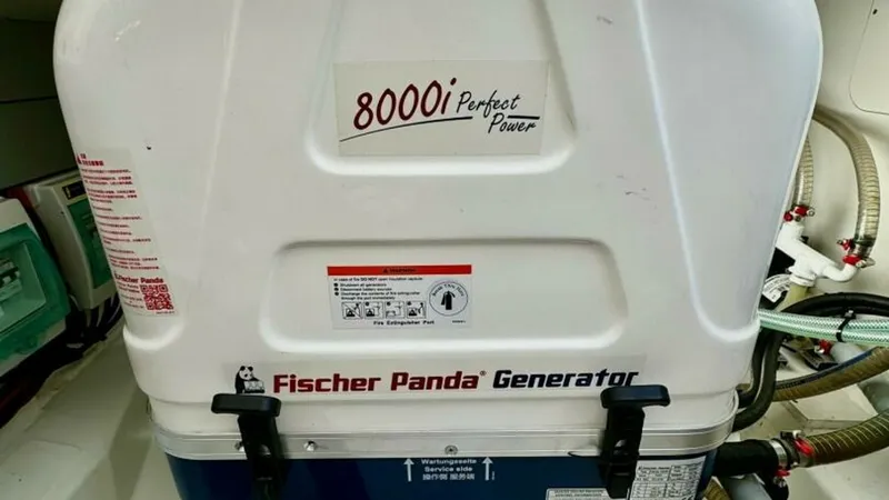Slide: The Image of Fischer Panda Generator Compartment This image showcases the Fischer Panda 8000i generator, a compact and efficient power source located within the vessel's engine compartment. The generator is neatly housed, highlighting its modern design and reliability, essential for extended cruising. I - 7403688