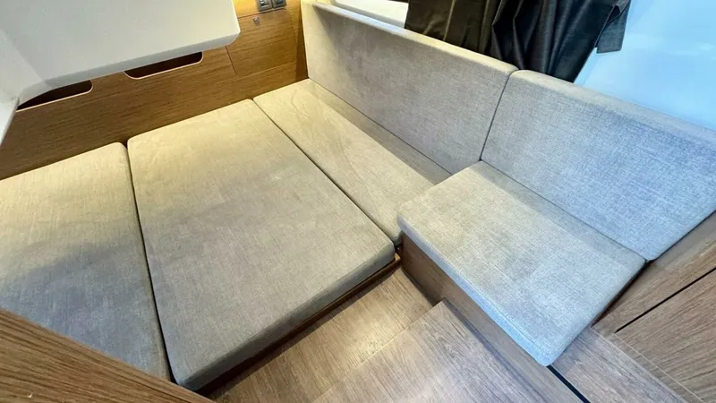 Slide: The Image of Convertible Dinette Seating Area This inviting dinette area on the Beneteau Antares 11 features plush, upholstered seating that converts into a comfortable sleeping space. The warm wood finishes and soft lighting create an intimate and cozy atmosphere, perfect for relaxing or dining. Lar - 7403685